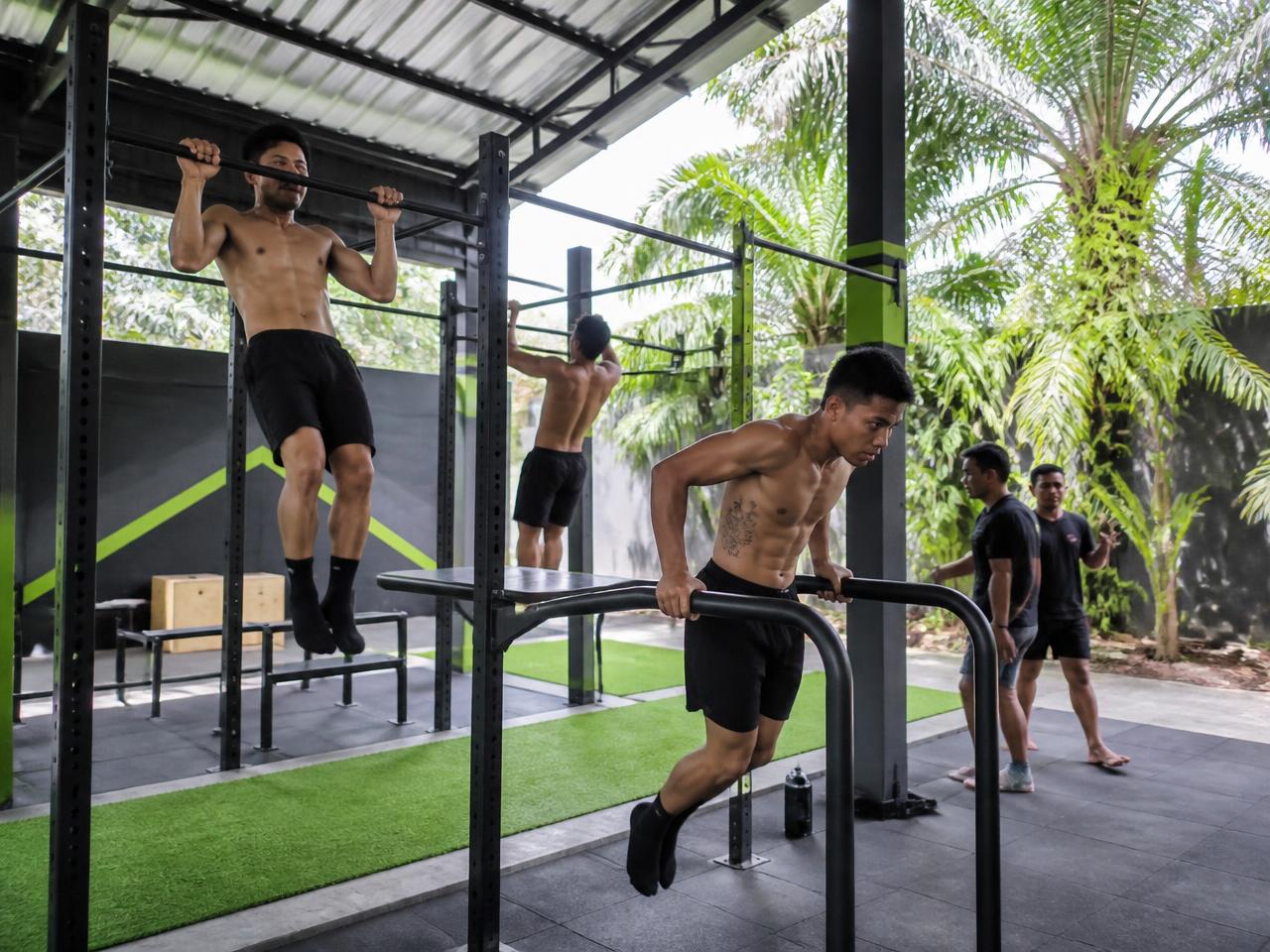 Athletes training on an outdoor calisthenics rig