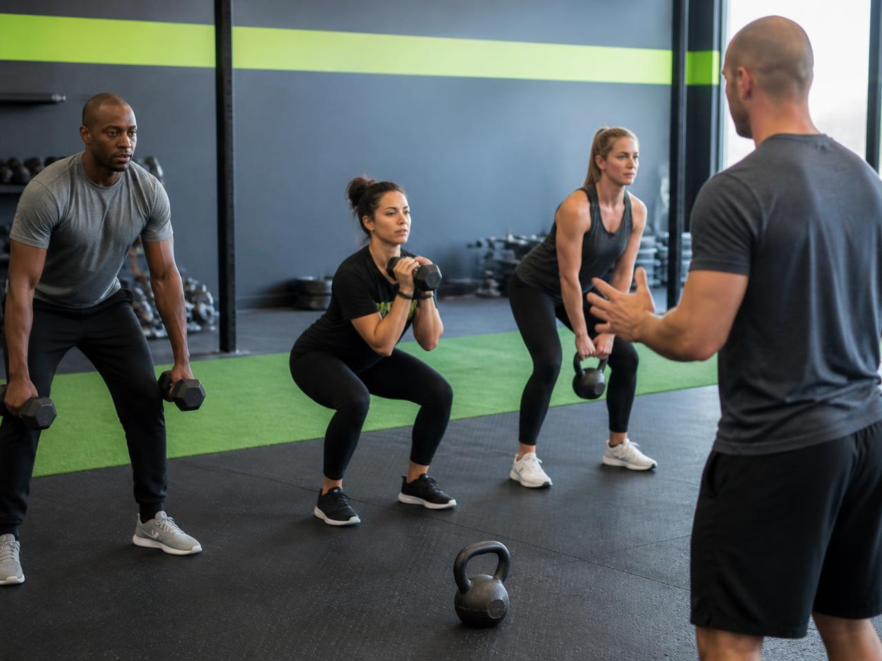 Small group training with dumbbells led by a coach